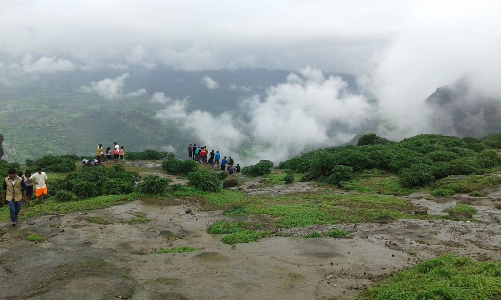Green hills near Lonavala half hidden by monsoon clouds, with walkers on a ridge