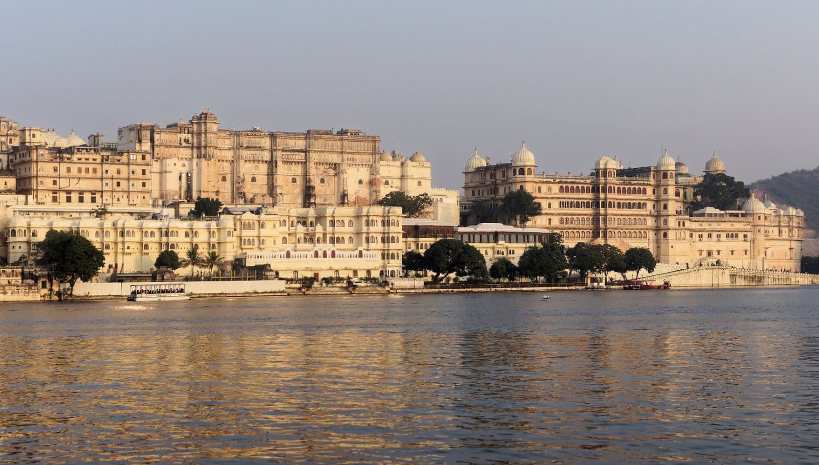 The City Palace of Udaipur stretching along the shore of Lake Pichola in warm light